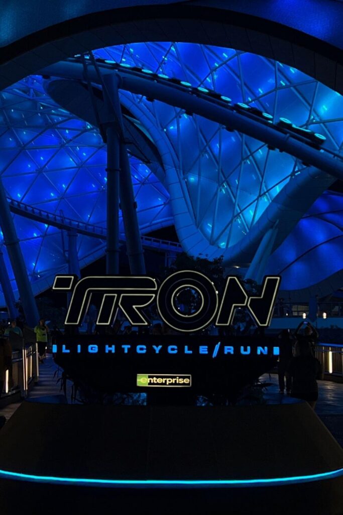 Photo of the entrance to TRON Lightcycle / Run behind Space Mountain. A group of cycles is speeding by in the background.