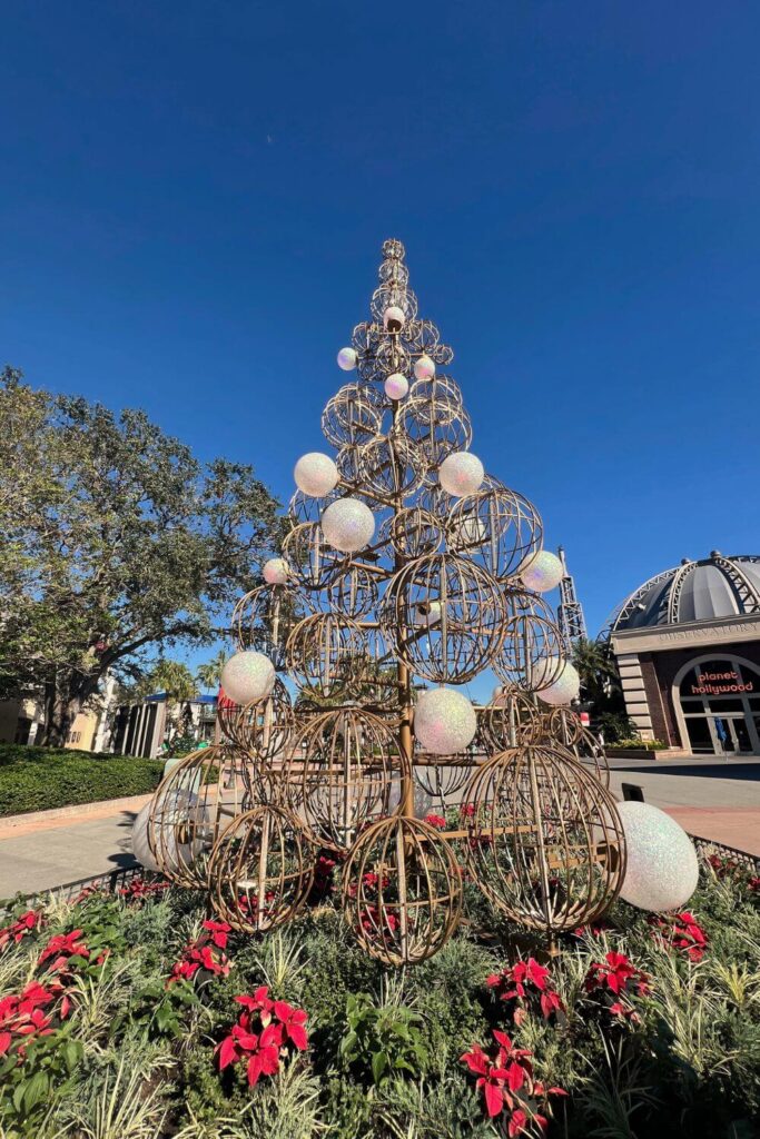 Photo of the Sphere Christmas tree sculpture at DIsney Springs comprised of gold and white spheres.